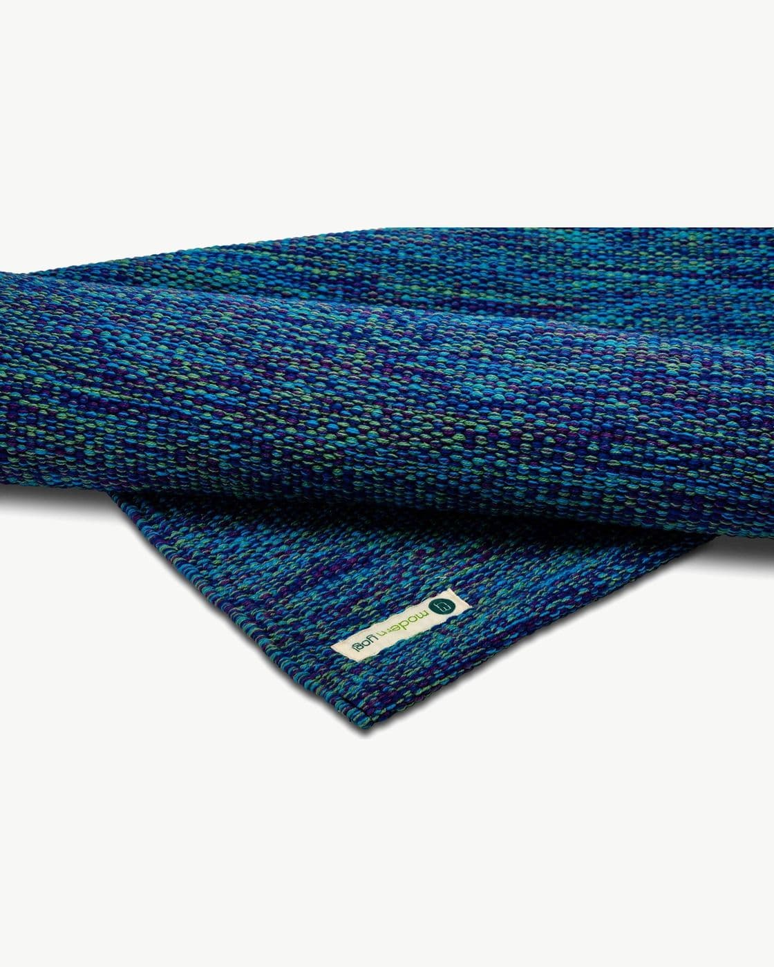 Le coin replié d’un tapis de coton bleu, qui montre les deux faces